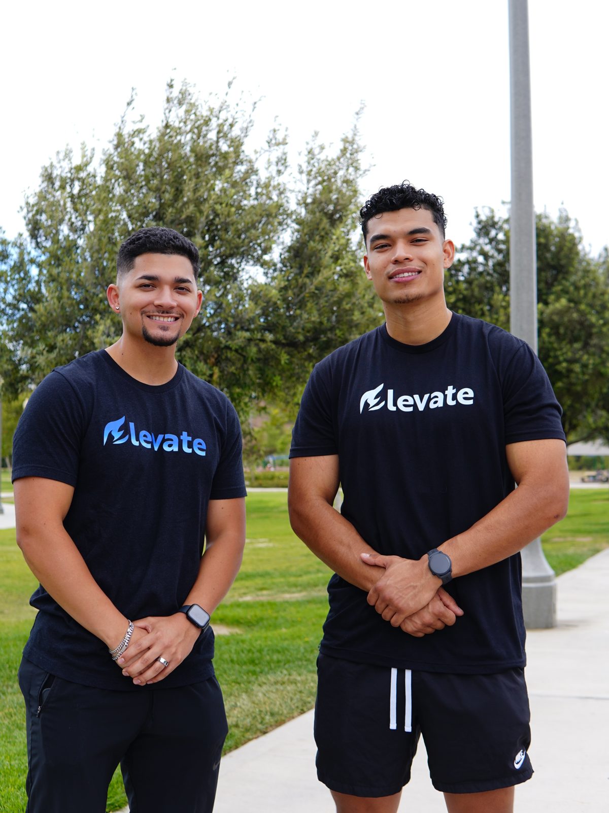 Two members of the Elevate fitness community in branded gear